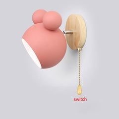 A  Mickey Mouse style Pink wall sconce with E27 sockets attached to a wall with a chain switch.