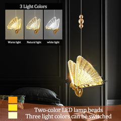 Colourful metal butterfly pendant light glowing warm white in a stylish bedroom.