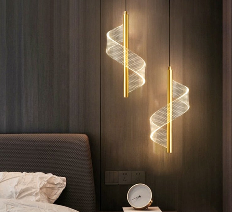 Two LED indoor hanging lamps with a gold-colored shade, mounted on a dark wall, providing light to the area below.