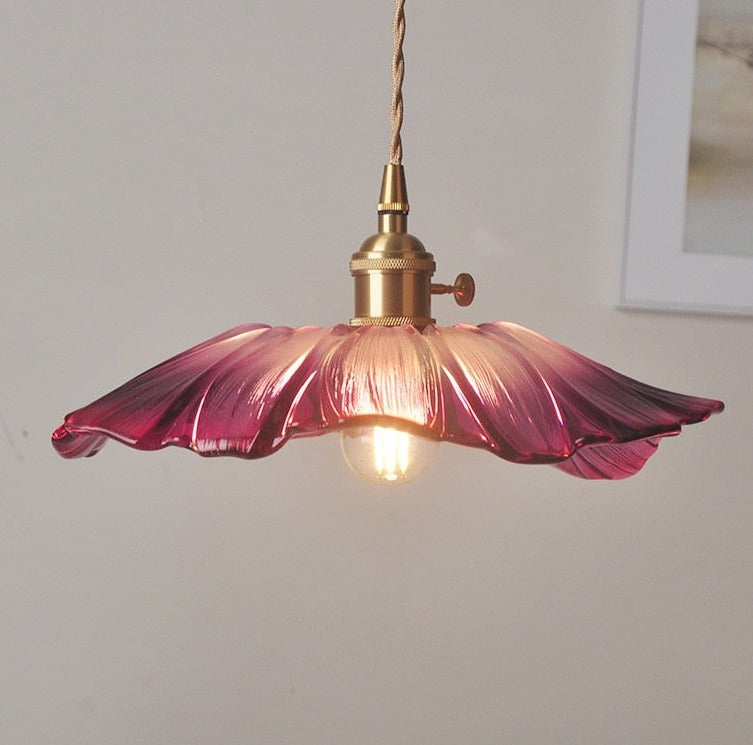 A pendant LED light fixture with a pink glass shade and a knob switch, mounted on a wall.