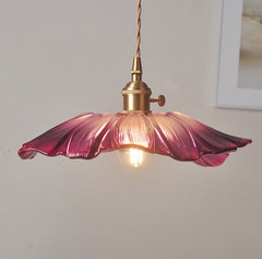 A pendant LED light fixture with a pink glass shade and a knob switch, mounted on a wall.