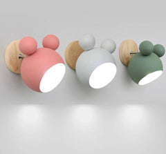 A collection of  three Mickey Mouse style colorful wall sconces with E27 sockets in various colours attached to a wall.