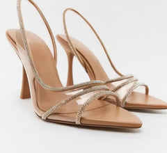 A pair of sling-back heels featuring crystal-clear PVC straps and a shimmering rhinestone trim with high heels side view.