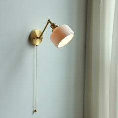 A wall fixture with a hand-crafted white ceramic shade.